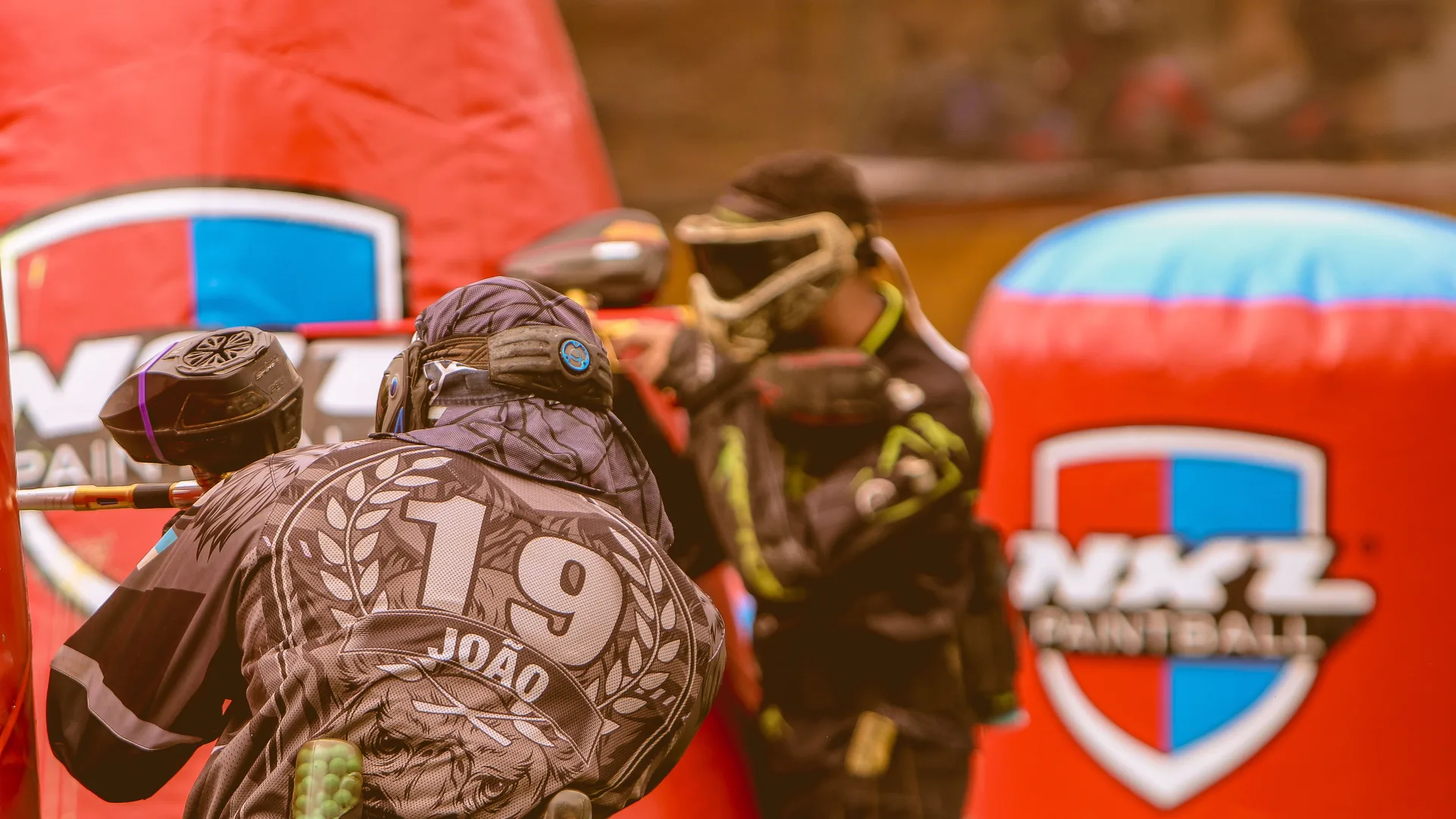 Atletas federados em campo durante uma partida de paintball
